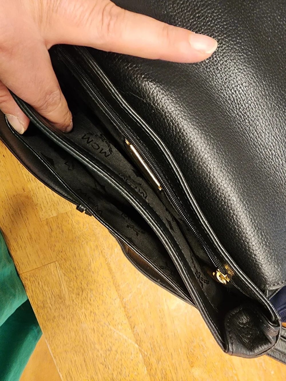 vintage MCM black pebbled leather studded crossbody bag featuring a front plaque